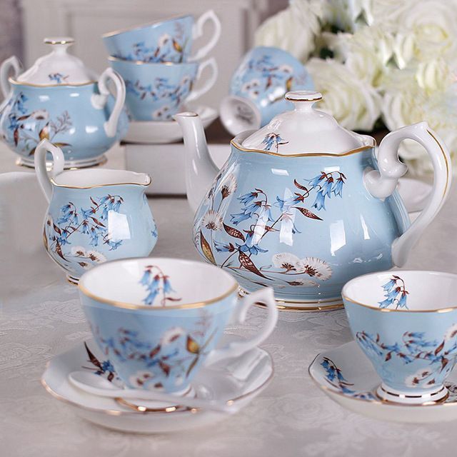 blue and white porcelain tea set with matching saucers, cups and saucers on a table