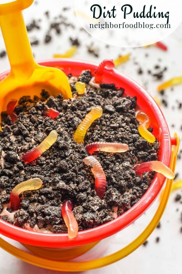 a red bowl filled with dirt and yellow handled shovels on top of white surface