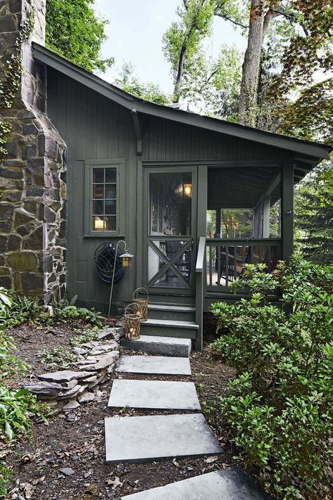 a small cabin in the woods with steps leading up to it's front door