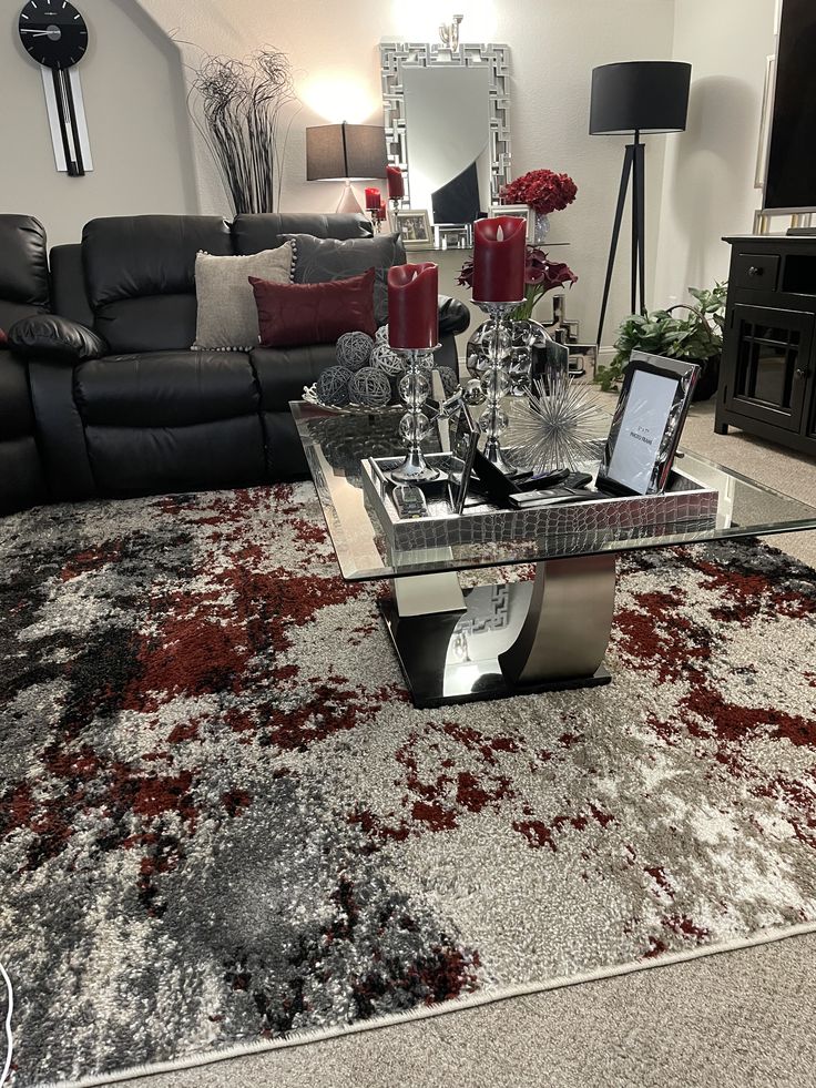 a living room filled with furniture and a red rug on top of a carpeted floor