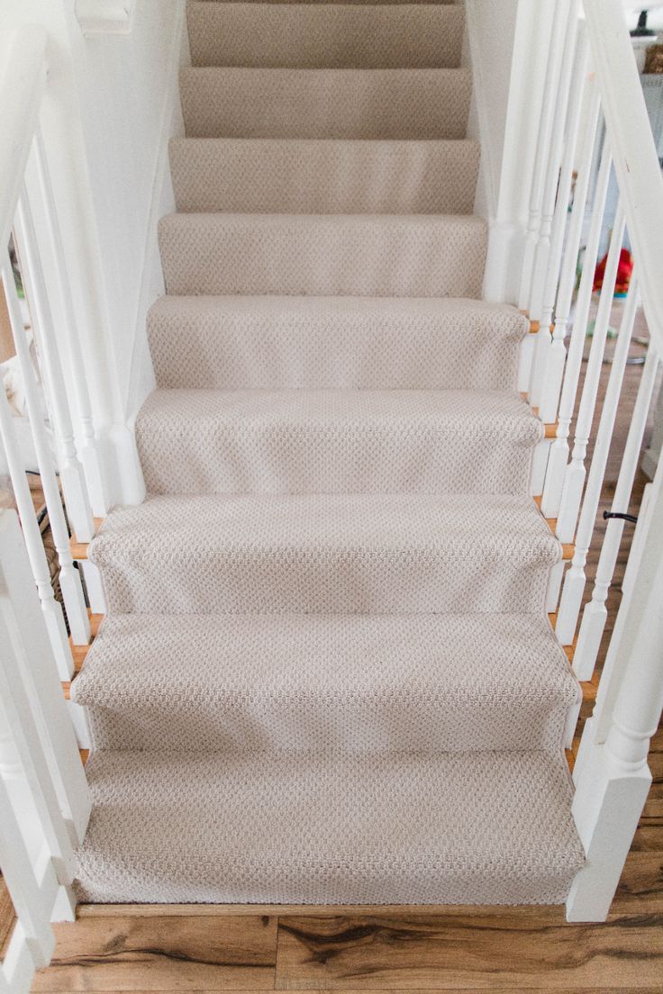 a set of white stairs with beige carpet