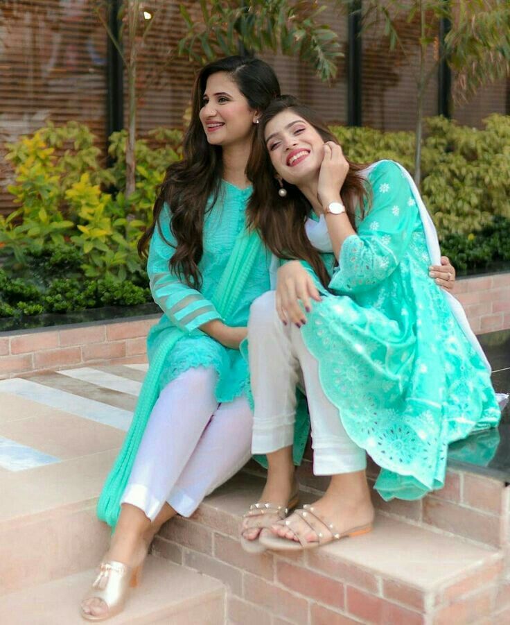 two women are sitting on the steps together