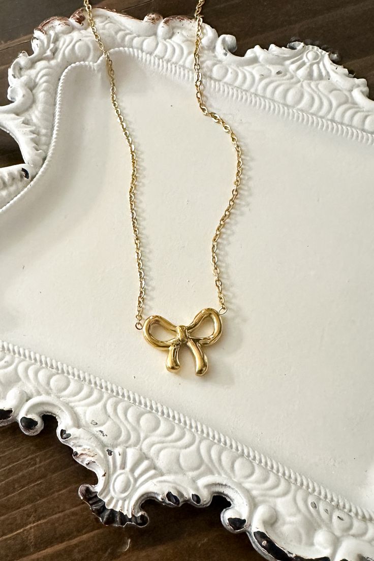 Get ready to amp up your style with our adorable Dainty Bow Necklace! Wrap yourself in charm and sweet simplicity with this gorgeous necklace featuring a tiny bow pendant. Timeless Design: The delicate bow design adds a timeless and feminine touch to your style. High-Quality Stainless Steel: Crafted with precision and durability in mind, our necklace is made from high-quality stainless steel, ensuring longevity and resistance to tarnish. Versatile Finishes: Choose between the classic elegance of Chic Ribbon Jewelry As A Gift, Chic Jewelry With Ribbon For Gift, Chic Ribbon Jewelry For Gifts, Chic Ribbon Jewelry Gift, Chic Ribbon Necklace Perfect For Gifts, Chic Ribbon Necklace For Gift, Feminine Ribbon Necklace As Gift, Feminine Bow Jewelry For Gift, Feminine Ribbon Necklace For Gift