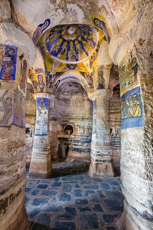 the interior of an ancient building with painted murals on it's walls and columns