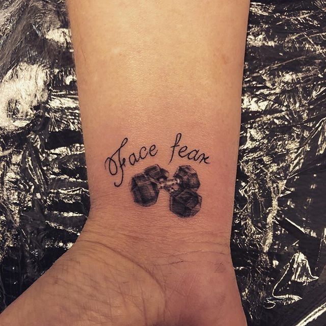 a small tattoo on the wrist that says, force team with paw prints in black ink