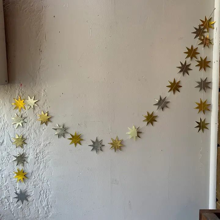 some gold and silver stars are hanging on the wall