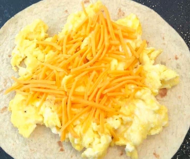 a tortilla topped with cheese and other toppings on top of a counter