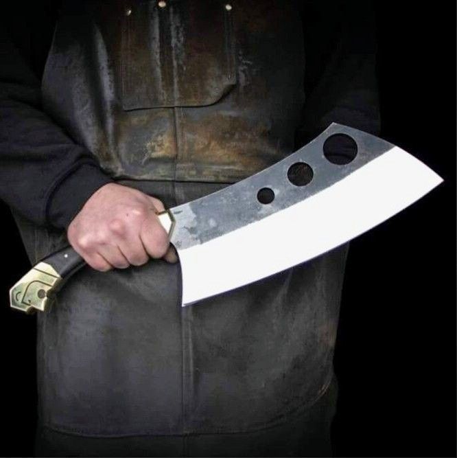 a man holding a large knife with holes in it