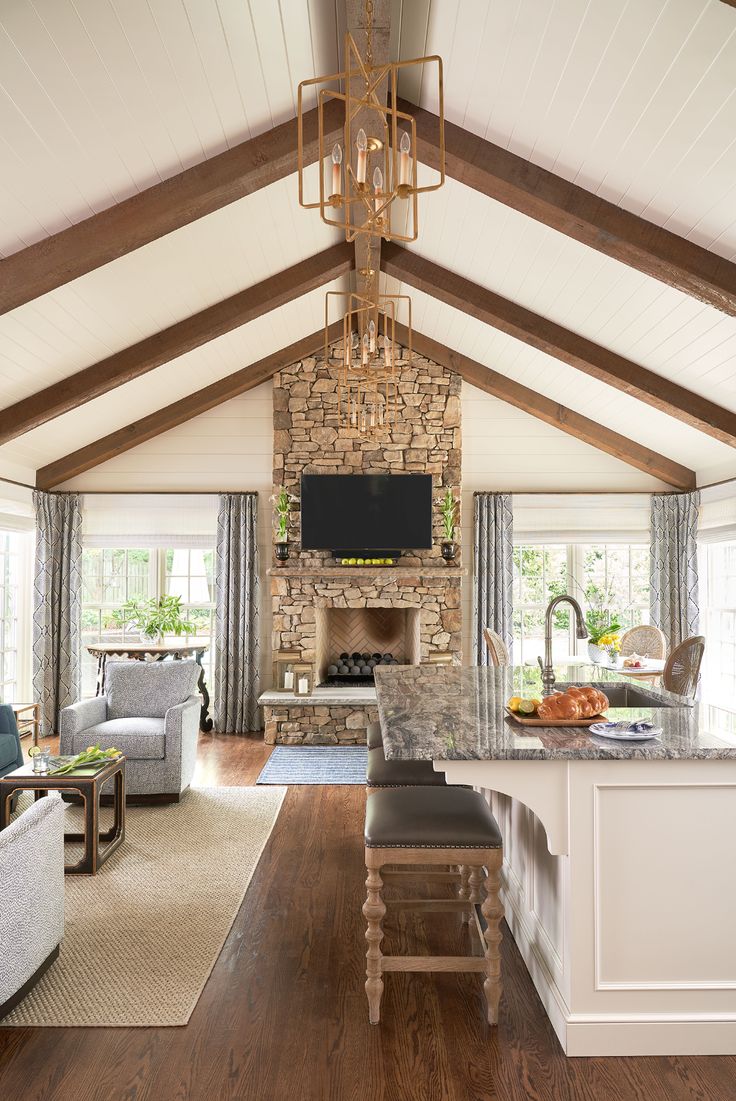 a living room filled with furniture and a fire place in the middle of a kitchen