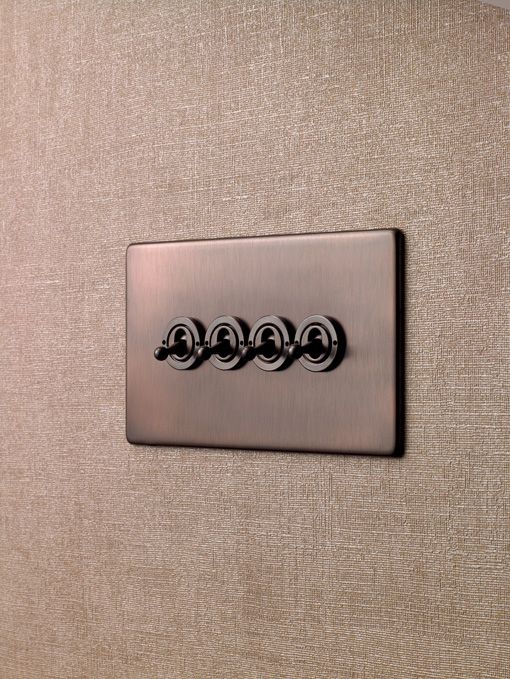 a close up of a metal button on a beige fabric wall with three circles in the middle