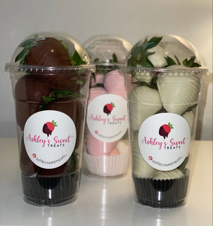 three plastic cups filled with chocolate covered strawberries