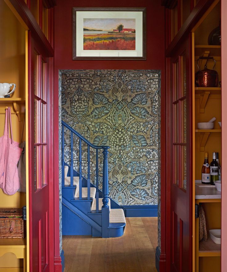 an entry way with red walls and blue stairs