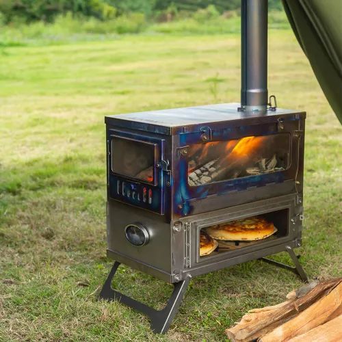 a stove that is sitting in the grass next to some logs and a tent with it's door open