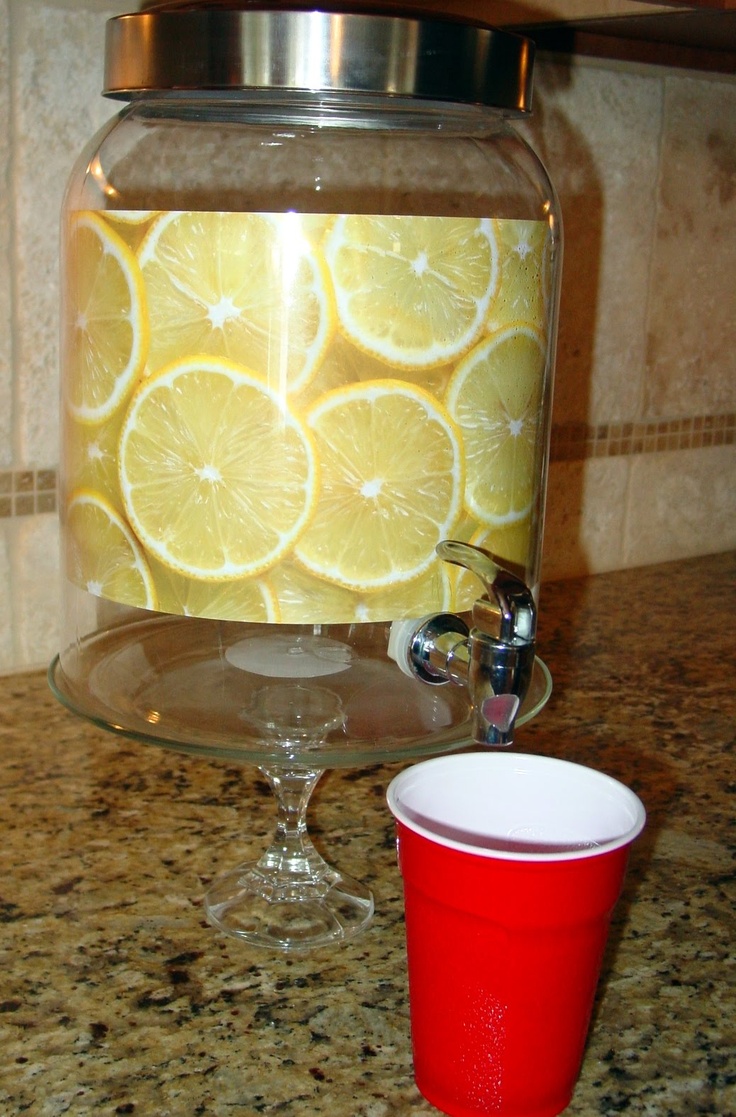 there is a cup and some lemons on the counter next to a canister