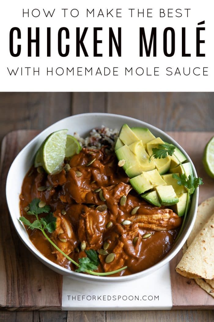 a bowl filled with meat and avocado on top of a wooden cutting board