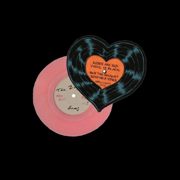 an orange and black heart shaped record on a pink disc with the words, love is in