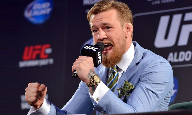 a man in a suit and tie holding a microphone