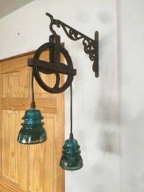 an old fashioned light fixture hanging from the side of a door with two bells attached to it