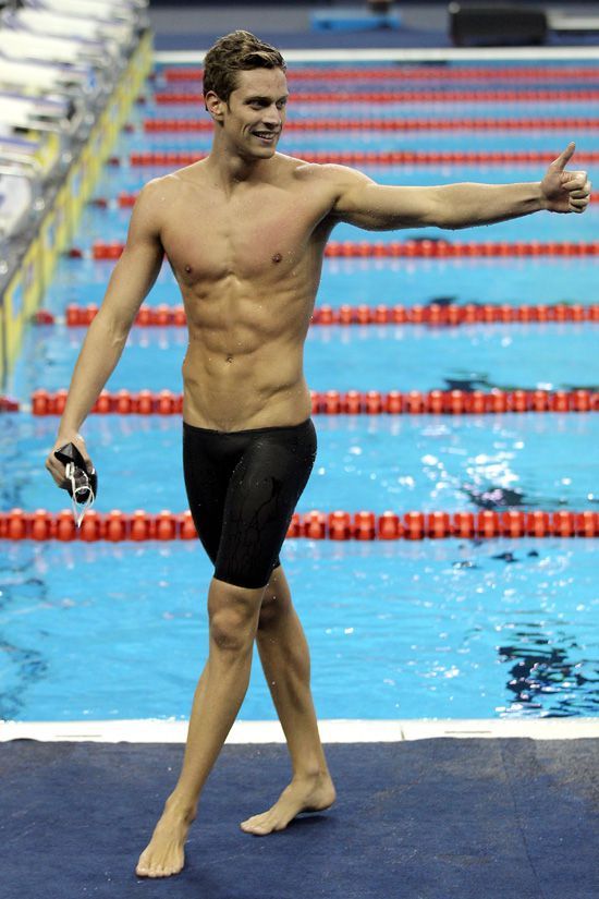 a man standing on top of a swimming pool holding his arm out to the side