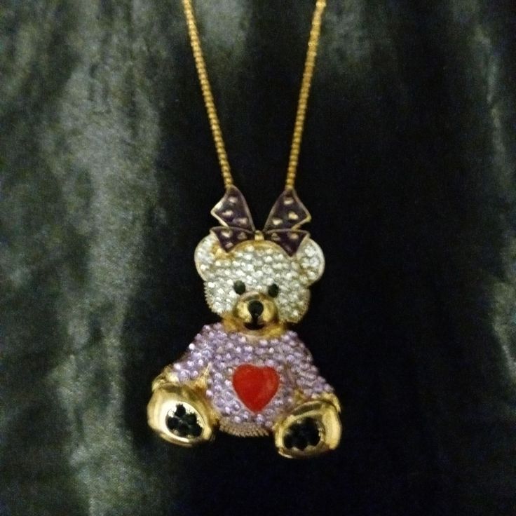 This Is A Large Gold Toned Alloy Pendant Shaped Like A Teddy Bear Dressed In A Purple Heart Sweater With A Big Purple Box On Top Of Her Head. Her Fur And Sweater Are Encrusted With Sparkling White And Purple Rhinestones. Her Heart, Bow, And Other Features Are Done In An Enamel Overlay. She Comes On A Long, Thick, Gold Toned Alloy Chain That Falls Mid Chest. New With Tags. Gold Seashell Necklace, Xo Necklace, Teddy Bear Pendant, Bear Pendant, Seashell Necklace, Heart Sweater, Purple Rhinestone, A Teddy Bear, Amethyst Necklace