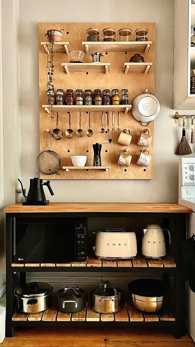 a wooden shelf with pots and pans on it next to a wall mounted pot rack