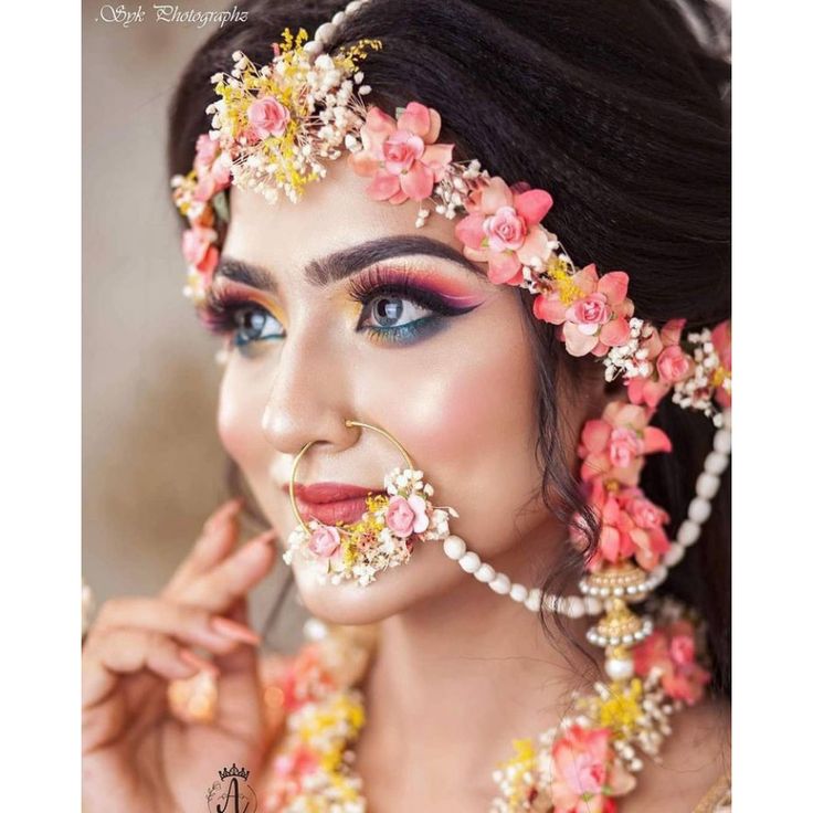 a woman with flowers in her hair and makeup