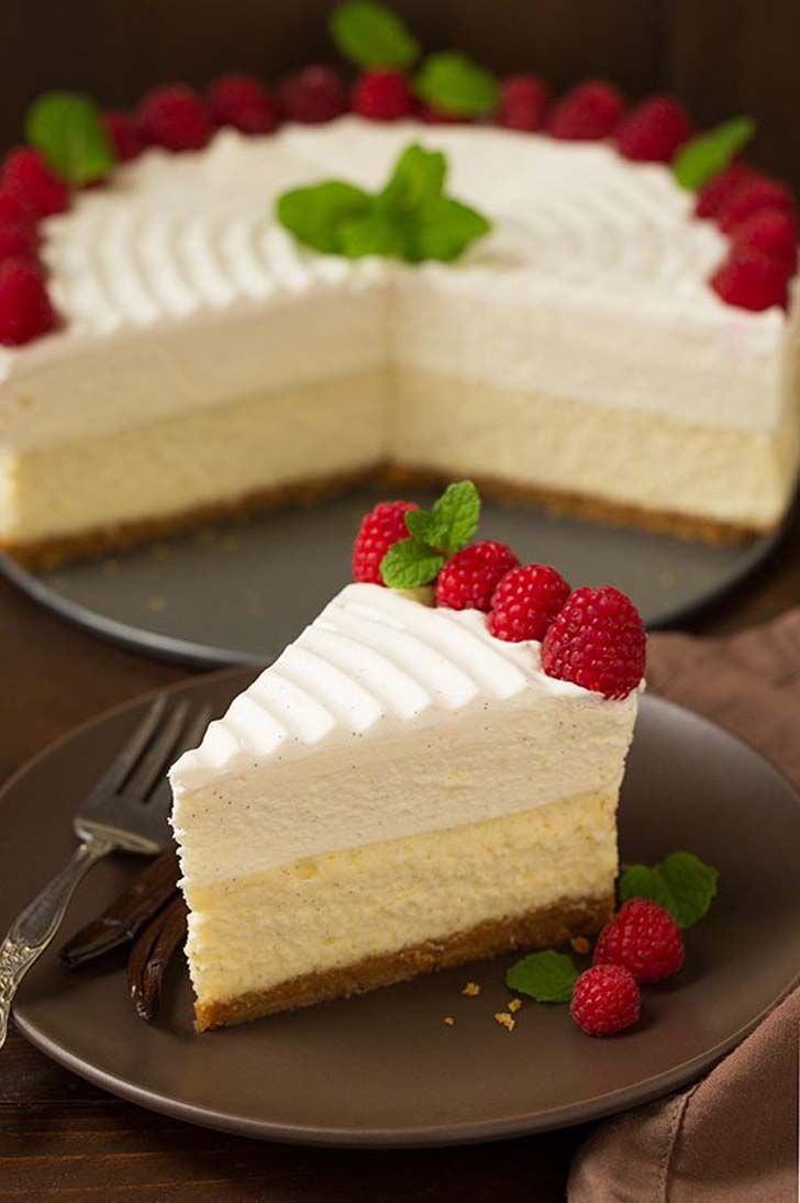 a slice of cheesecake on a plate with raspberries next to the cake