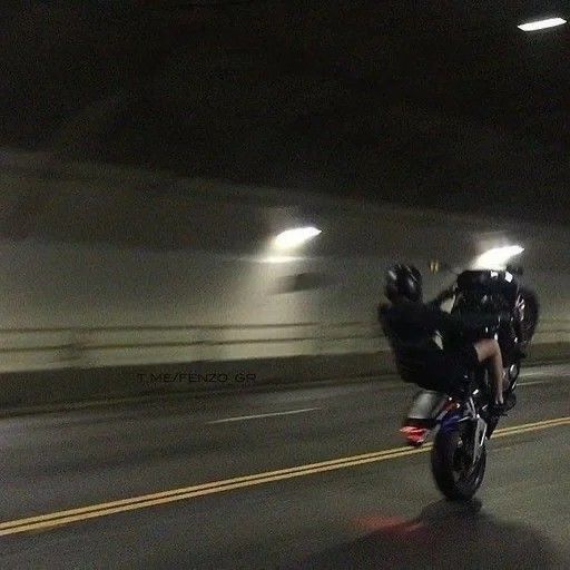 two motorcyclists are riding down the road in an underground parking garage area