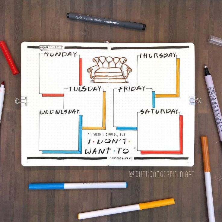 a planner with markers, pens and pencils next to it