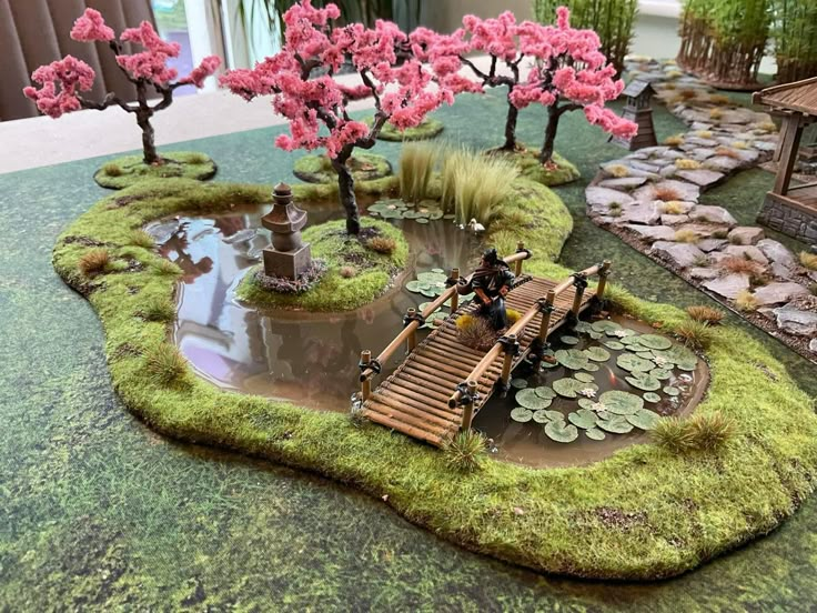 a miniature garden with pink trees and water lilies