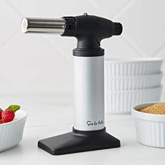 a white and black blender sitting on top of a counter next to bowls with strawberries