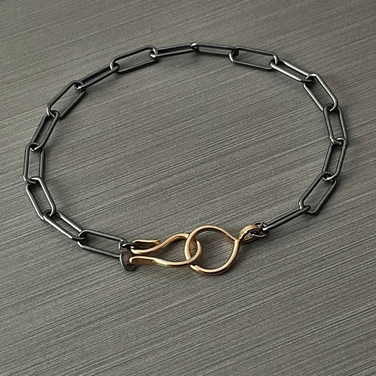 This Sterling Silver and 14k Gold Fill Paperclip Bracelet is the perfect modern accent for any outfit. Crafted from a 4.3mm patina sterling silver chain, this bracelet features a 14k gold filled hook clasp, mixed metal design. The timeless style of this piece makes it an easy choice for everyday wear. Details: Chain: Sterling Silver Paperclip Chain, 4.3mm, patina finish Clasp: 14k Gold Fill Hook and ring clasp Sizes: 6 inches to 10 inches, full and half sizes Shipping: Ready to ship within one b Elegant Adjustable Chain Bracelet With Hooks And Links, Modern Chain Link Bracelet With Hooks And Links, Modern Gold Bracelets With Sterling Silver Clasp, Metal Jewelry With Box Clasp For Everyday, Elegant Gold Bracelet With Hook And Links, Everyday Metal Jewelry With Box Clasp, Modern Link Paperclip Bracelet With Hooks, Modern Everyday Chain Bracelet With Hook And Links, Modern Link Chain Bracelet With Sterling Silver Clasp