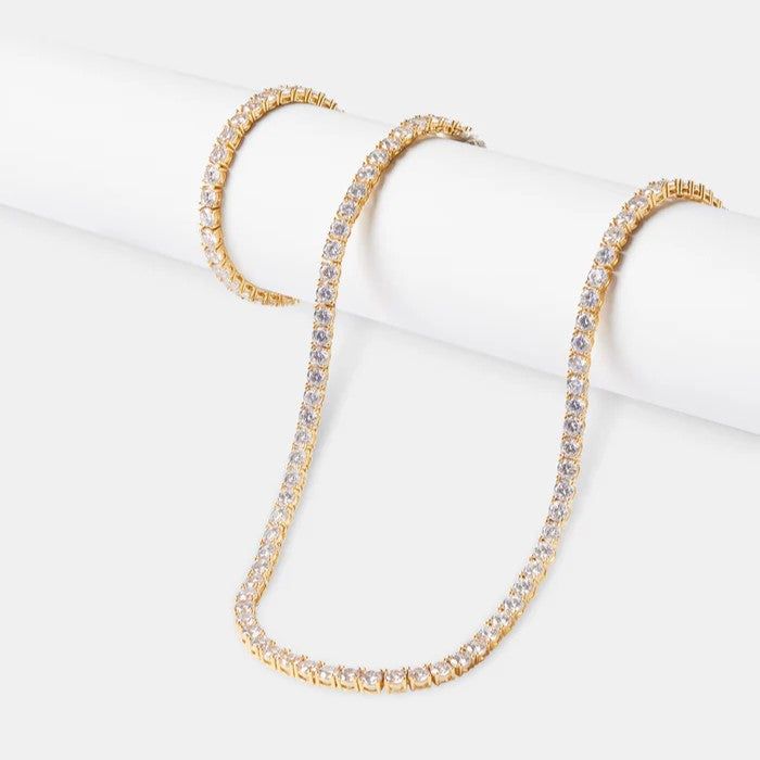 Elevate your everyday elegance with the exclusive "Jewels Essence 20" Diamond Tennis Chain Necklace." Available in the warm hue of gold or the timeless luster of silver, this quintessential piece is designed to add a touch of luxury to your personal collection. Each necklace is meticulously set with a single row of brilliant-cut diamonds, selected for their exceptional clarity and radiance. The fluidity of its design ensures it drapes gracefully, making it a versatile accessory suitable for both day and evening wear. The seamless cascade of sparkle it provides is sure to turn heads and elevate any ensemble. The resplendent sparkle is set against your choice of rich gold or sleek silver, creating an alluring contrast that catches both the light and the gaze of onlookers. Each diamond is per Gold Tennis Necklace With Diamond Accents As A Gift, Elegant Cubic Zirconia Tennis Necklace, Gold Cubic Zirconia Jewelry With Box Chain, Gold Crystal Chain Jewelry, Gold Tennis Necklace With 17 Jewels As A Gift, Gold Luxury Tennis Necklace, Gold Crystal Tennis Necklace For Anniversary, Gold Diamond Chain Necklace For Everyday Luxury, Gold Crystal Necklace Fine Jewelry