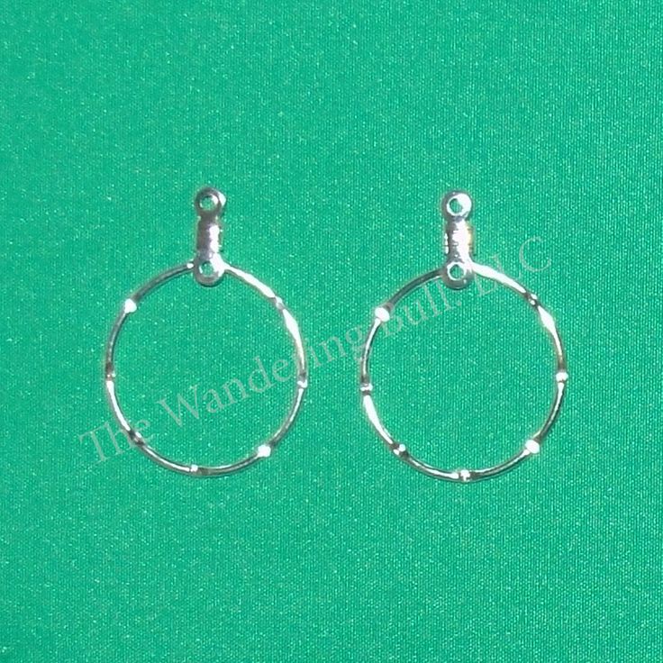 two small silver hoop earrings on a green background with the word, it was made from metal