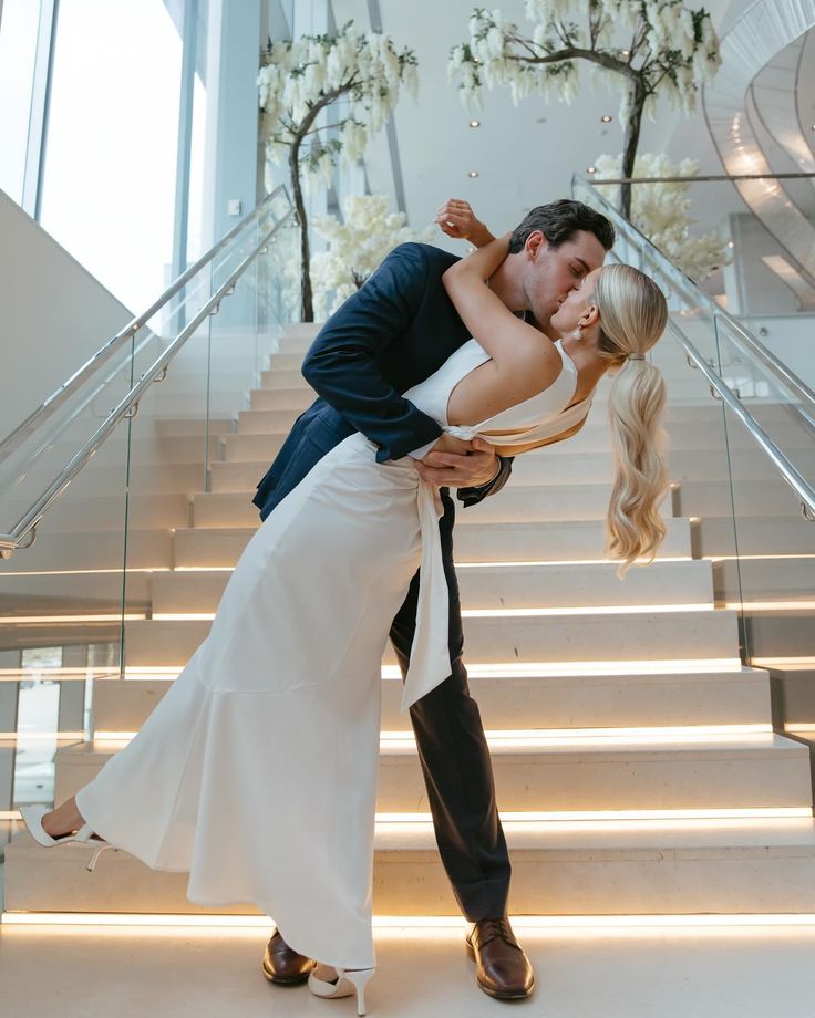 a bride and groom kissing on the stairs