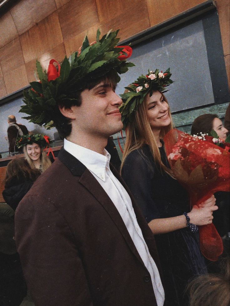 two people with flowers on their heads are smiling