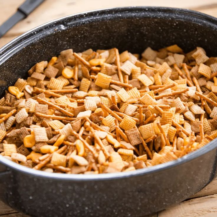 a pan filled with cheetos sitting on top of a wooden table