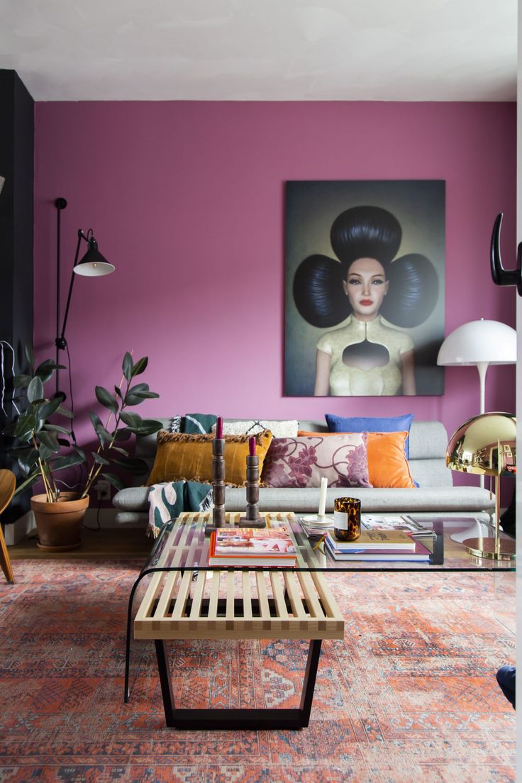 a living room filled with furniture and a painting on the wall above it's coffee table