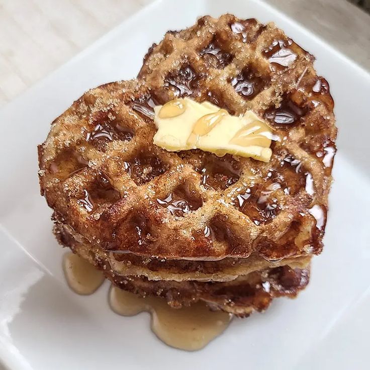 two waffles on a plate with syrup and butter