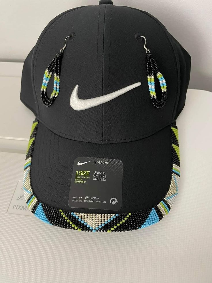 a black hat with a white nike logo on the front and a pair of earring clips attached to it