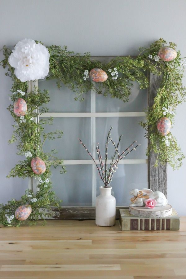 an old window frame is decorated with flowers and greenery for a spring mantel