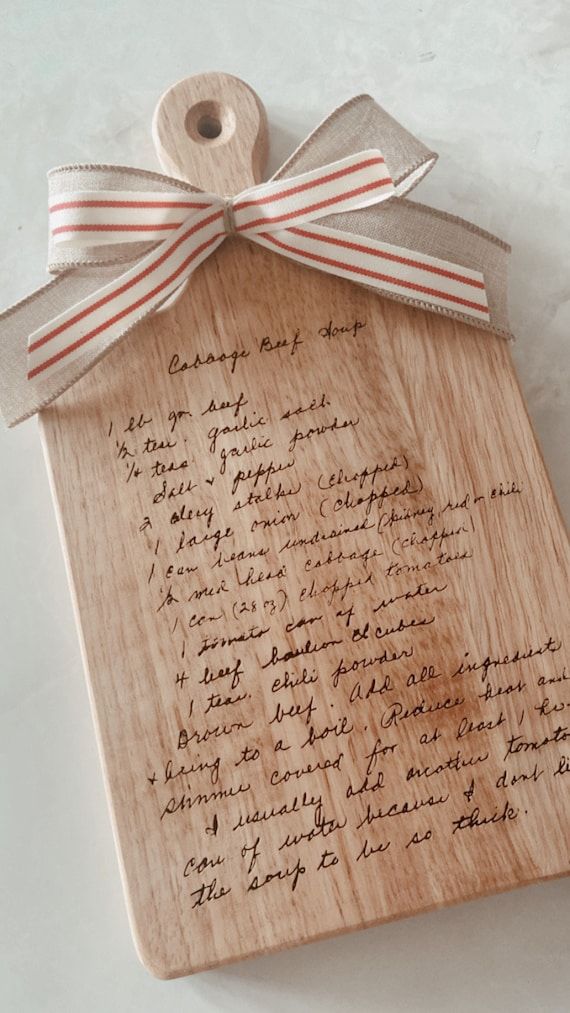 a piece of wood with writing on it and a ribbon tied around the top of it