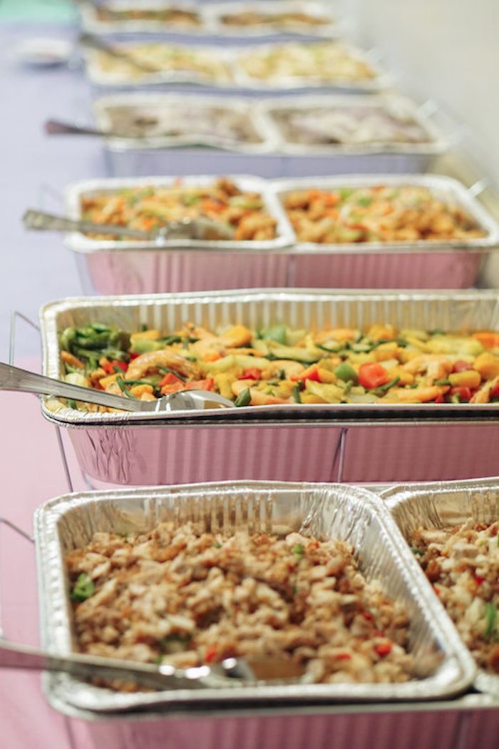 several trays of food are lined up on a table