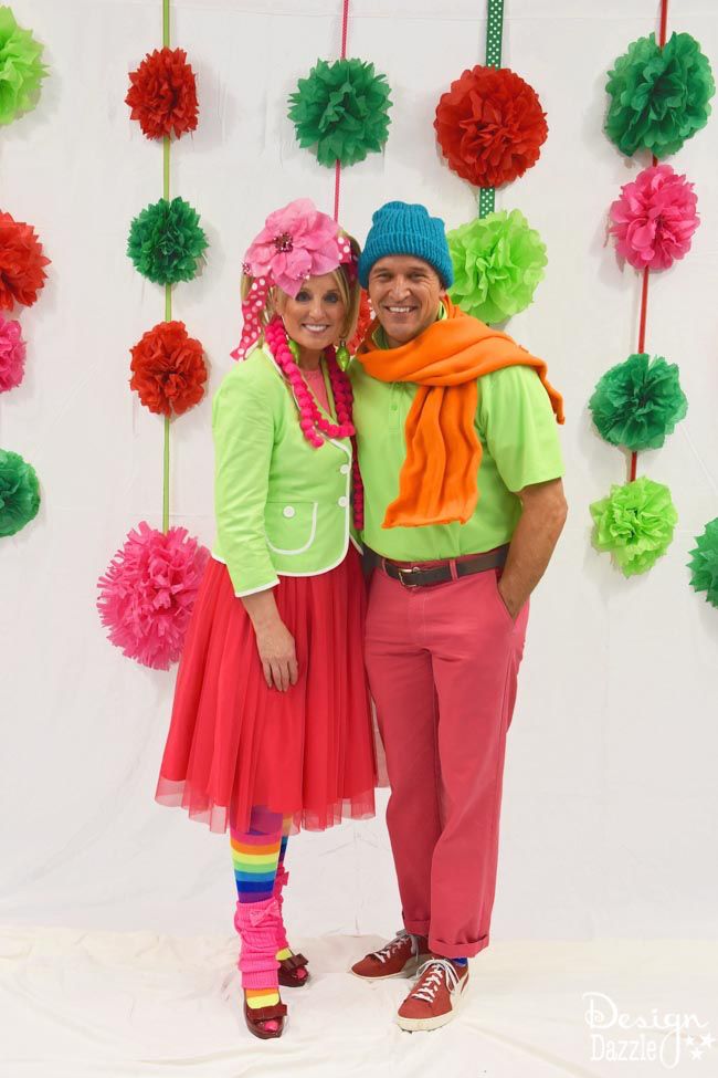 a man and woman posing for a photo in front of pom - poms