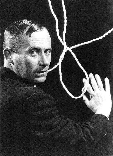 a black and white photo of a man holding a rope