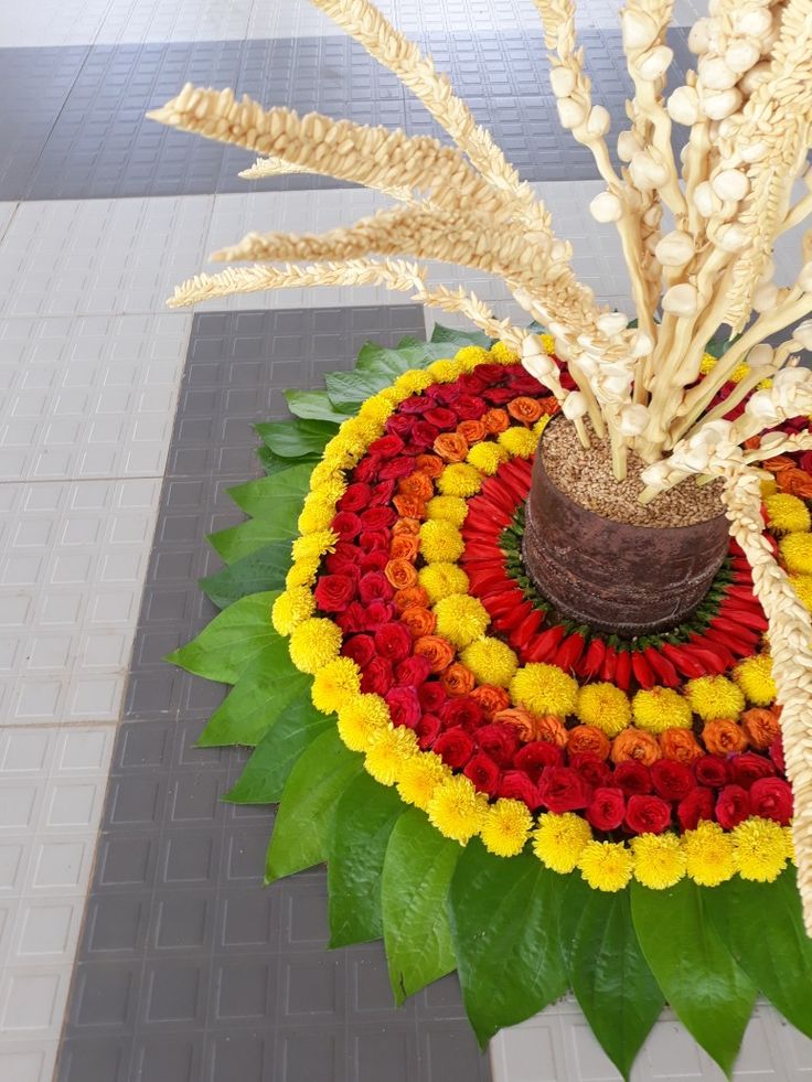 an arrangement of flowers is arranged in a circle on top of a tile flooring area