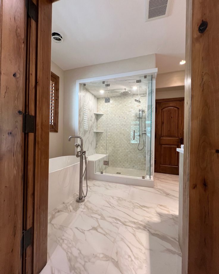 a bathroom with a walk in shower next to a bathtub and sink under a window