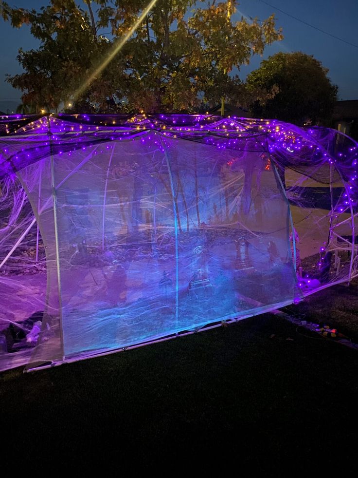 an outdoor tent with purple lights on it