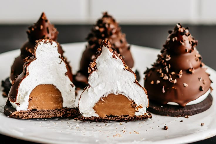 three desserts on a white plate with chocolate and marshmallows in the shape of trees