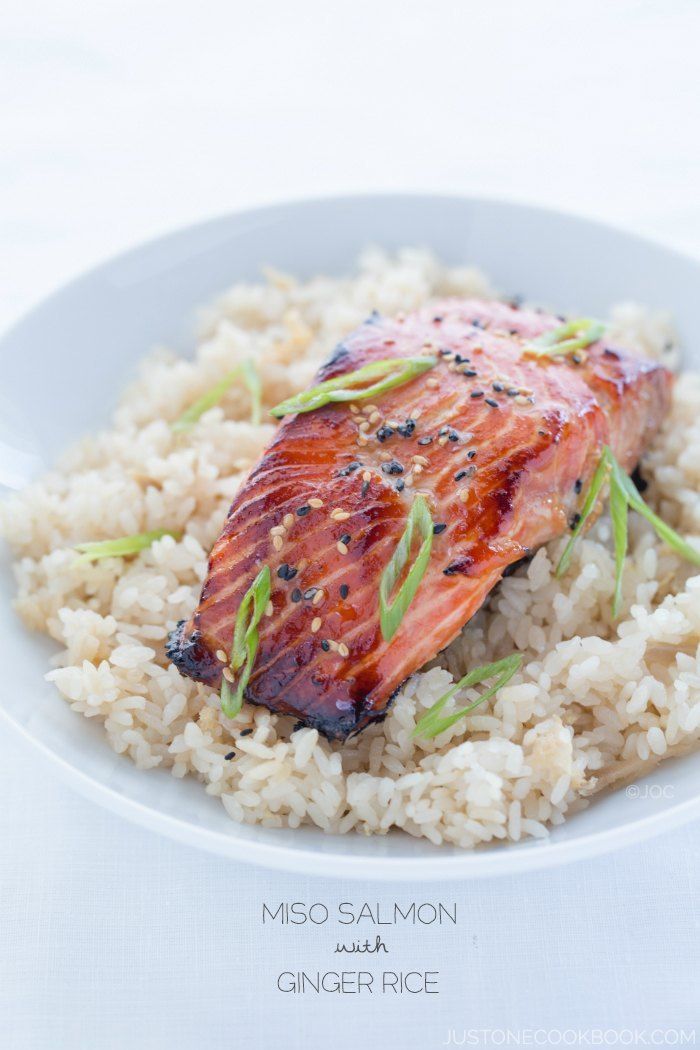 a white plate topped with rice and salmon